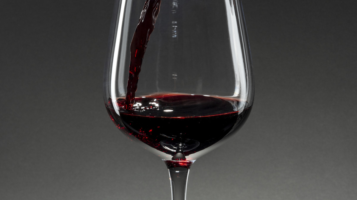 gros plan sur un verre de vin rouge sur fond gris